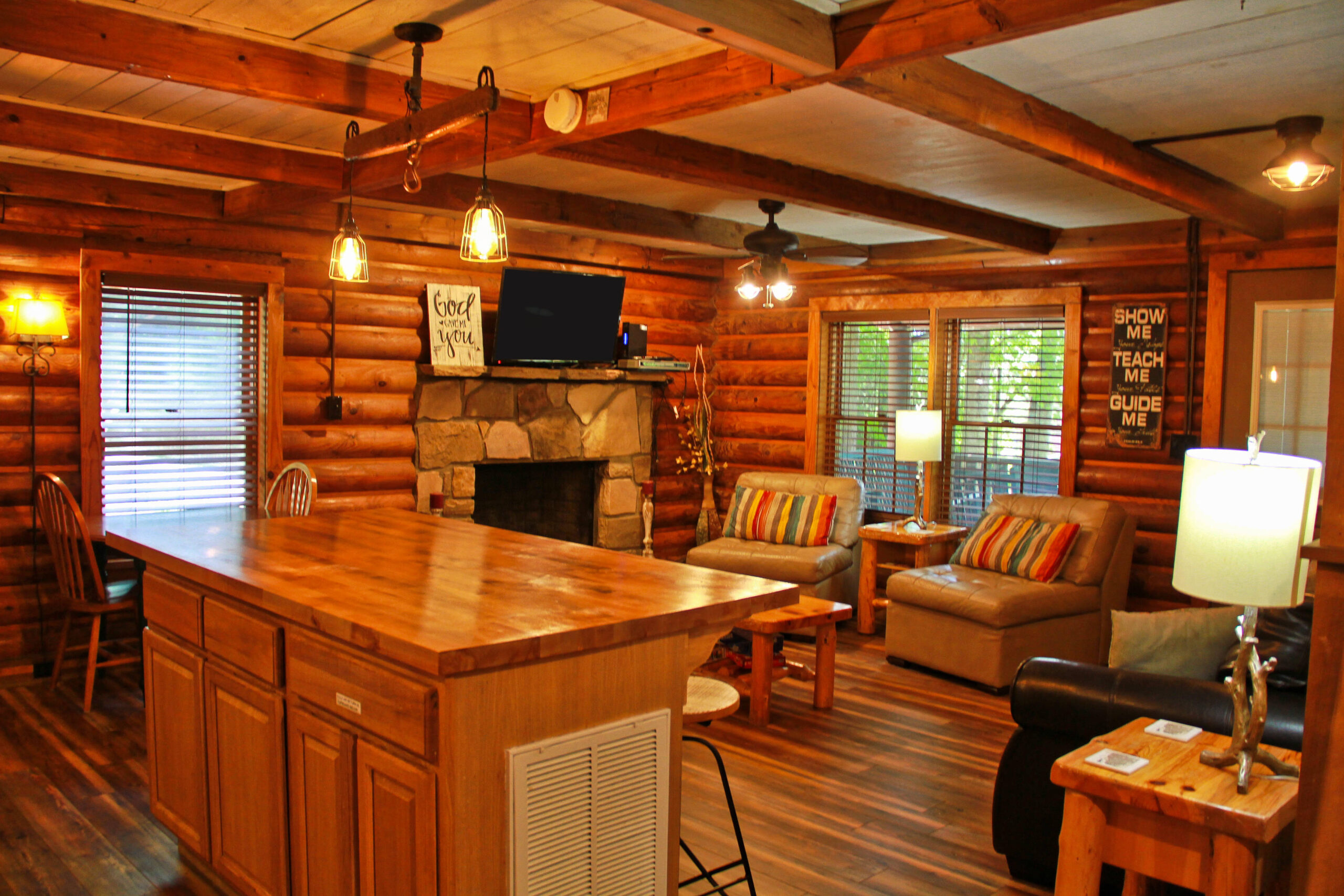 view of living room area with stone fire place and TV