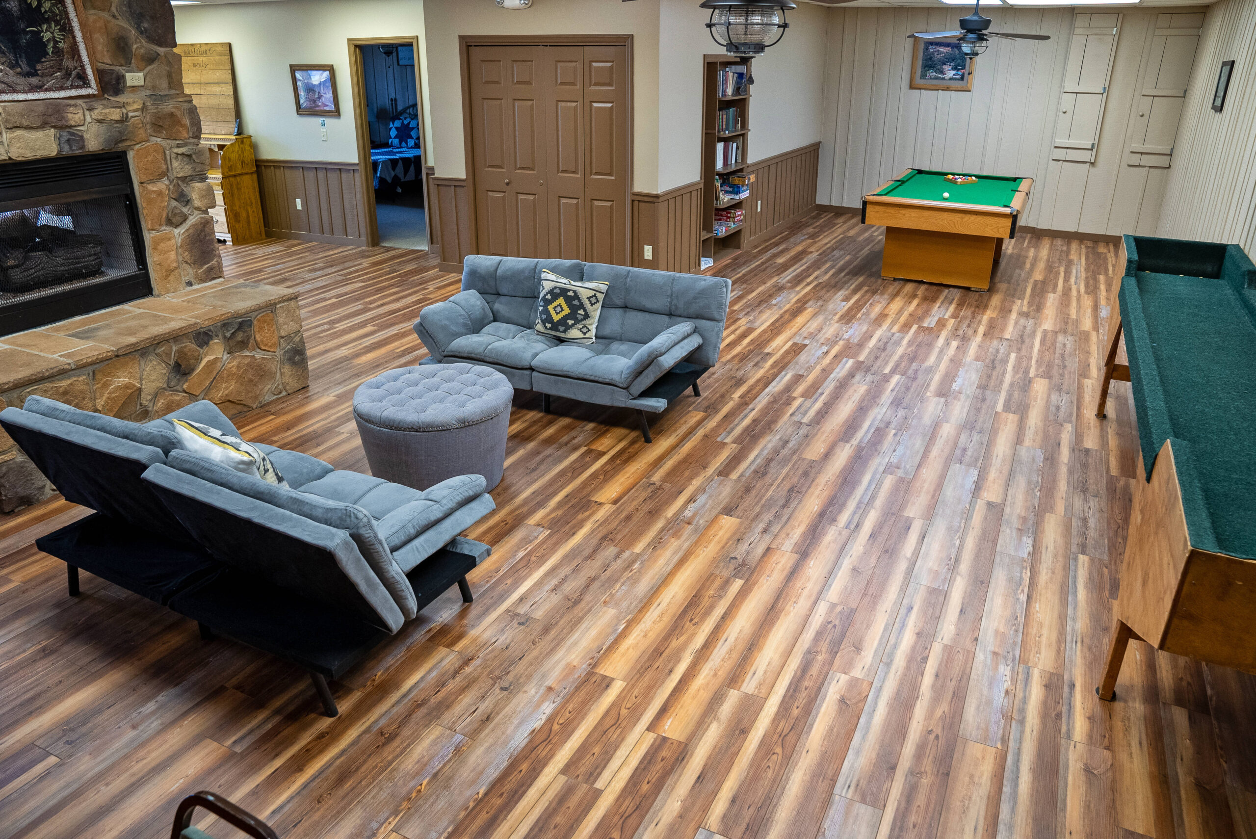 game room area with sofas and stone fireplace