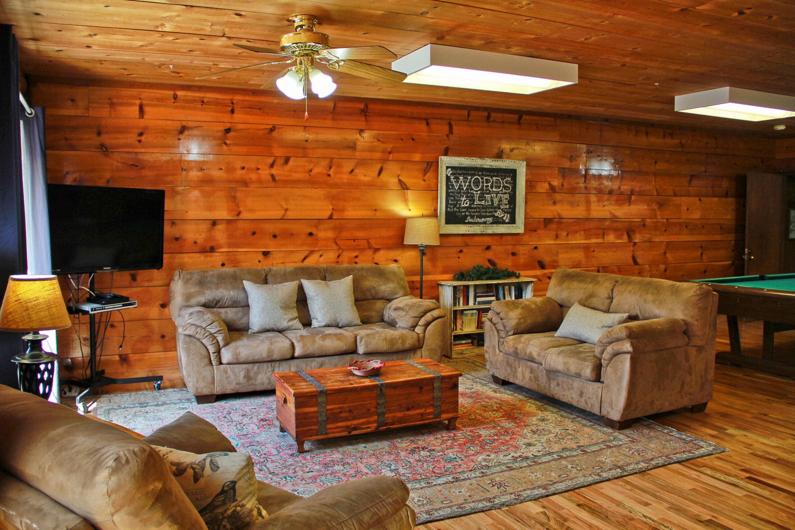 upstairs living room area with pool table, sofa chairs and TV